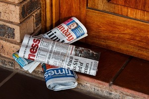 Three newspaper on a doorstep